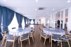 two tables and chairs in a room with blue drapes at 15BR SwimmingPool Villa Golf View Snooker BBQ in Bayan Lepas +37 photos