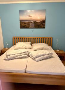 2 camas en un dormitorio con una pintura en la pared en Friesenhof, en Friedrichskoog