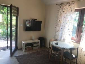 a living room with a table and a tv on the wall at Mazurski Domek Brożówka 50 m od plaży in Brożówka