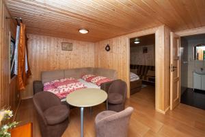 Habitación con sofá, mesa y sillas. en Domki, pokoje u Małgosi en Sztutowo