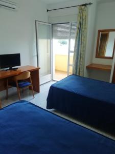 a bedroom with a bed and a desk and a computer at Hotel Balisa in Níjar