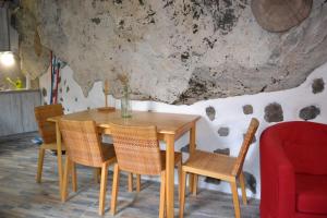comedor con mesa de madera y sillas en Casa Cueva El Pedregal Tejeda en Tejeda