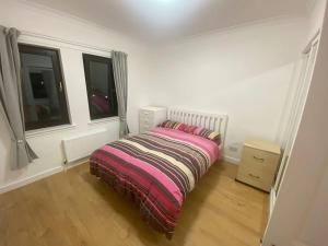 ein Schlafzimmer mit einem Bett mit einer gestreiften Decke in der Unterkunft Steps Away from All the Action in Edinburgh