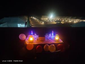 a table with candles and lights on a street at night at The Jaisalmer Heritage Safari Camp in Sām