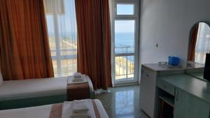 Habitación de hotel con cama y ventana grande en Krai Moreto Guest House, en Ahtopol