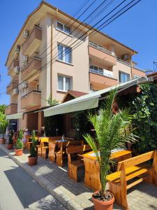 a hotel with tables and chairs and a building at AMORE Obzor in Obzor