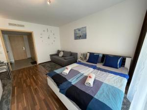 a bedroom with a large bed and a couch at Relax and Spa - DeLux Apartman in Velence
