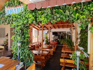 a restaurant with wooden tables and a bunch of plants at AMORE Obzor in Obzor