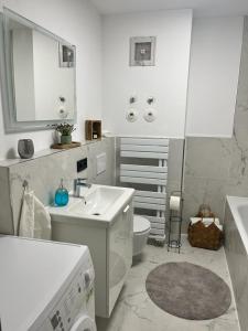 a white bathroom with a sink and a toilet at Schöne Terassenwohnung in Böblingen