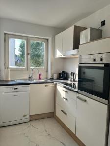 a kitchen with white cabinets and a sink and a microwave at Schöne Terassenwohnung in Böblingen