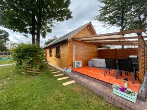 Woodland في Łagów: منزل به سطح خشبي مع شواية