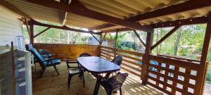 a wooden deck with a table and chairs on it at Mobil-home 6 personnes sur terrain 600 m2 in Vias