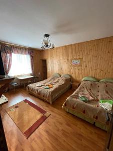 a bedroom with two beds and a table and a desk at РІТО in Slavske +24 photos