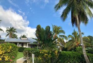 a house with palm trees in front of it at The Harbourview - Vava'u in Toula