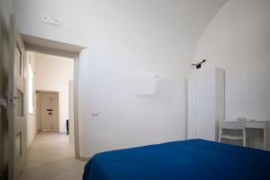 um quarto com uma cama azul e uma parede branca em ELISA Dependance Centro em Vietri