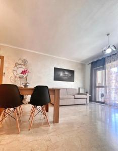 a living room with a table and chairs and a couch at Vittory house in Lido di Ostia