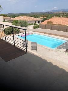a swimming pool with a chair next to a building at Villa neuve avec piscine in Bonifacio