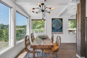 comedor con mesa, sillas y ventanas en Spacious Cottage With Scenic View en Dronningmølle