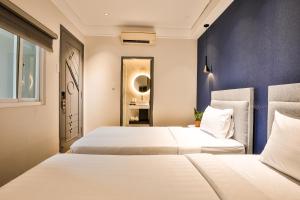 Duas camas num quarto com paredes azuis em La Paix Sài Gòn - Boutique Hotel em Ho Chi Minh