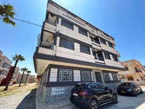 ein Gebäude mit zwei davor geparkt in der Unterkunft Appartement Relax Saidia in Saidia 