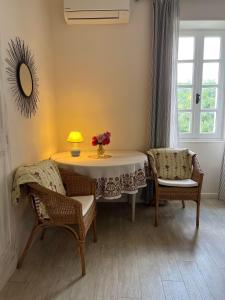 a room with a table and two chairs and a lamp at La ferme de tonton Jules et mamé Julia in Entraigues-sur-la-Sorgue
