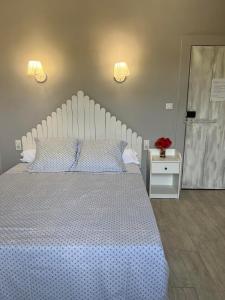 a bedroom with a large white bed and two lights at La ferme de tonton Jules et mamé Julia in Entraigues-sur-la-Sorgue