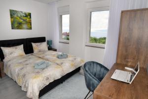 Schlafzimmer mit einem Bett, einem Schreibtisch und einem Laptop in der Unterkunft Commodious house in Rijeka with 5 bedrooms in Rijeka