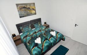 ein Schlafzimmer mit einem Bett mit einer grünen Bettdecke in der Unterkunft Commodious house in Rijeka with 5 bedrooms in Rijeka