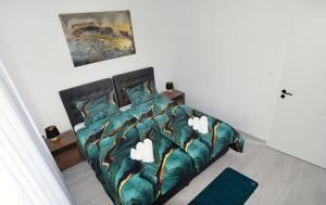 a bedroom with a bed with a green comforter at Commodious house in Rijeka with 5 bedrooms in Rijeka