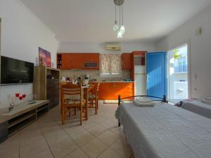 a bedroom with a bed and a kitchen with a table at Artemis Bakerys House 2 in Adamas