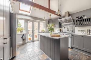 a kitchen with a large island in the middle at Stylish 2-Bed House With Office And Private Garden in Windsor