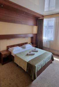 a bedroom with a large bed with two towels on it at Hotel Salem in Aktau