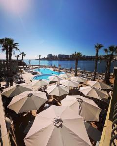 a large group of umbrellas and a swimming pool at Cavalieri Art Hotel in St. Julianʼs