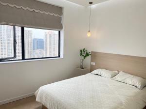 - une chambre avec un lit blanc et une fenêtre dans l'établissement Three Bedroom Apartment near Xintiandi, à Shanghai