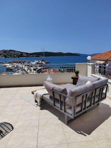 eine Couch auf einer Terrasse mit Blick auf den Yachthafen in der Unterkunft Apartment Čiovo Radić in Trogir