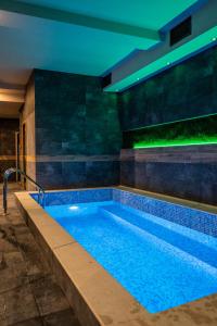 a swimming pool in a building with a lit up swimming pool at ADEO HOTEL Sport & SPA in Ruse