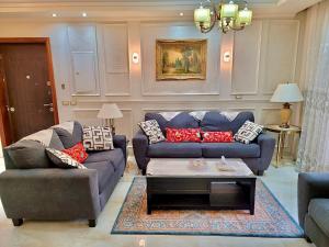 een woonkamer met 2 banken en een salontafel bij Ultra Luxury 3BR with Pools ,Sports ,Dining in Gated compound, Close to all sites in Caïro