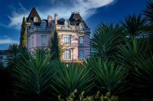 an old castle with palm trees in front of it at Flag Hotel Guimarães Fafe in Fafe