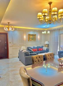 a living room with a table and a couch at Ultra Luxury 3BR with Pools ,Sports ,Dining in Gated compound, Close to all sites in Cairo