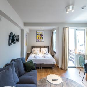 een woonkamer met een bed en een blauwe bank bij Japie rooms - in the heart of Antwerp in Antwerpen