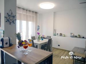 a living room with a table with two wine glasses on it at Appartamento Perla di Mare in Piombino