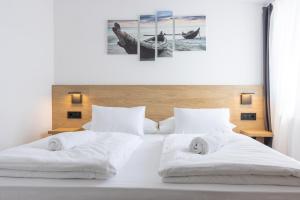 a white bed with two white towels on it at Apartments & rooms Stella Adriatica in Murter