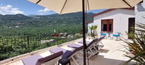 - un balcon avec une table, des chaises et un parasol dans l'établissement Villa Sarichel, à Nikithianós