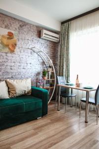 a living room with a green couch and a table at Aqua Vista Fratelli - Vedere Top la Mare si Lac - Summerland in Mamaia