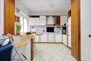 a kitchen with white cabinets and a table and chairs at Pigneto Cozy Flat in Rome