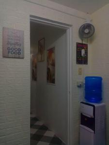 - un couloir avec une porte menant à une chambre dotée d'un ventilateur dans l'établissement The London Transient House, à Santo Tomas
