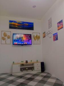 - un salon avec une télévision murale dans l'établissement The London Transient House, à Santo Tomas