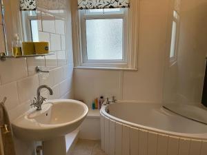 a white bathroom with a sink and a tub and a sink at Queens Gate in Portsmouth