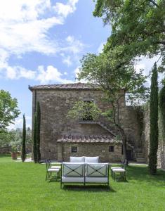 a table and chairs in front of a stone building at Pieve Aldina Relais & Ch&acirc;teaux in Radda in Chianti