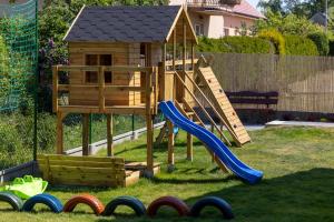 a playground with a slide and a play house at Seaside Escape Mielenko by Noclegi Renters in Mielenko